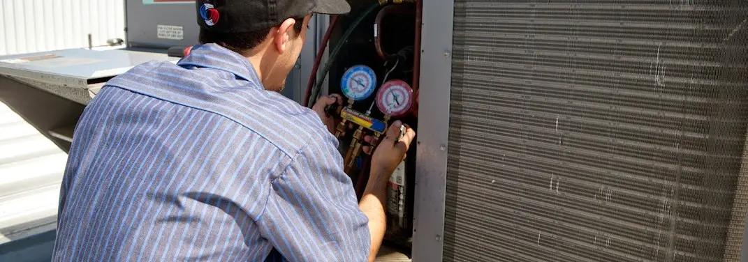 HVAC technician servicing a condenser unit in Union City